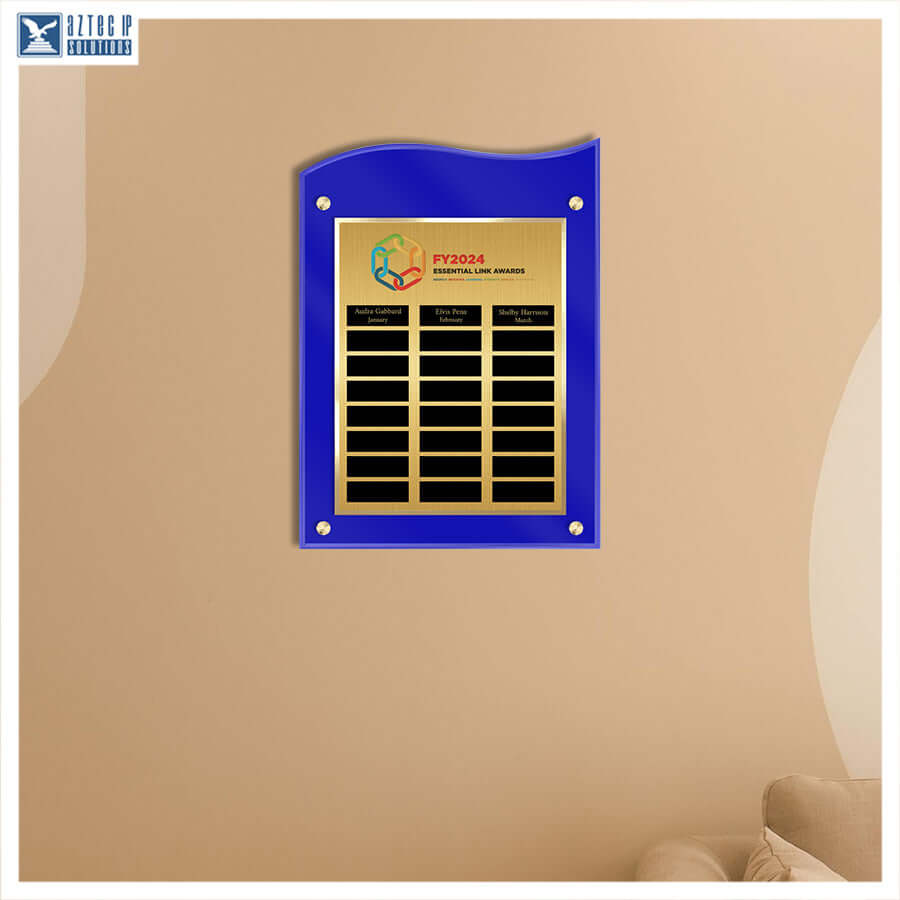 A custom acrylic and metal name plaque mounted on a beige wall. The plaque features a vibrant blue wavy outer frame and a gold-plated inner plate with black name slots and a colorful logo at the top.