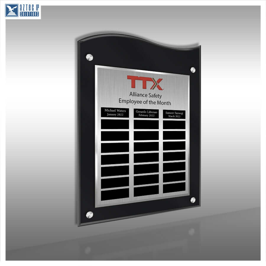 A custom black acrylic and brushed stainless steel employee of the month plaque on a gray gradient background. The plaque features the red TTX logo and three black nameplates at the bottom.