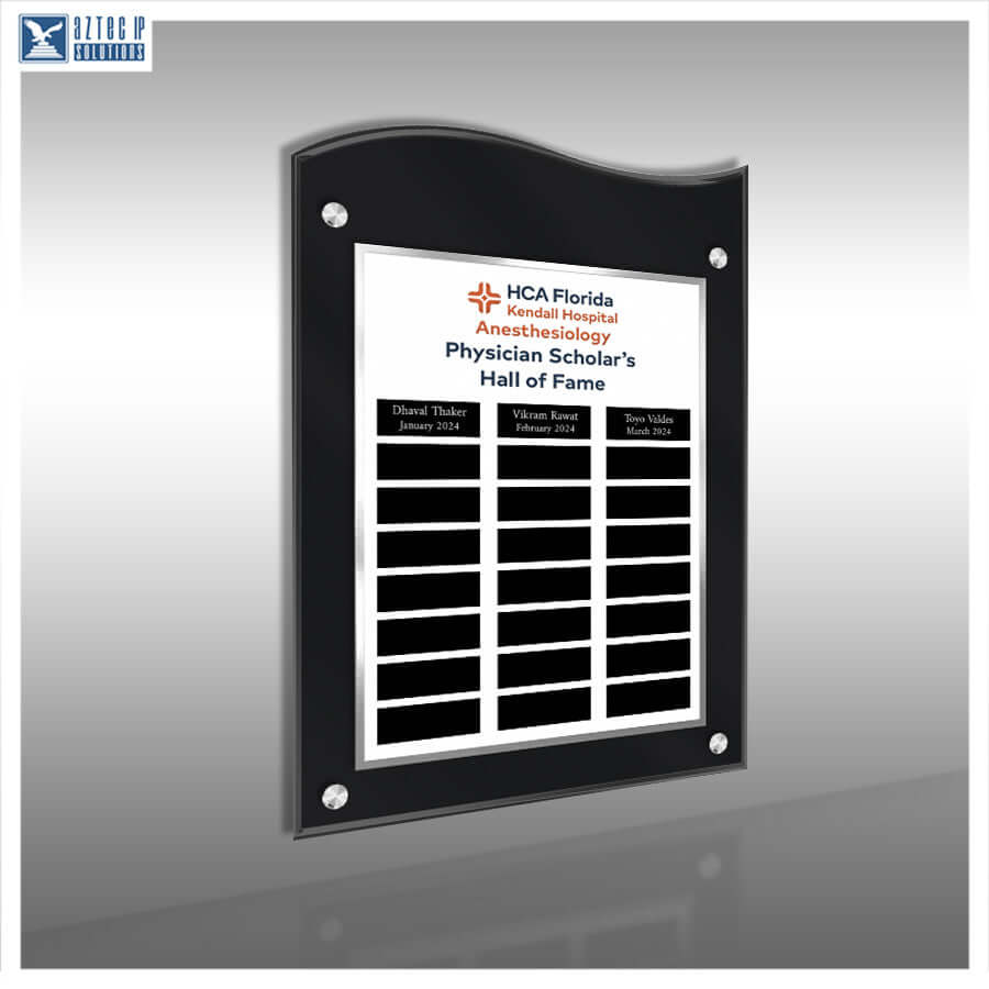 A black acrylic wall plaque with a white insert, mounted on a gray wall. The plaque features the HCA Florida Kendall Hospital Anesthesiology Physician Scholar's Hall of Fame logo and multiple black nameplates for customization.