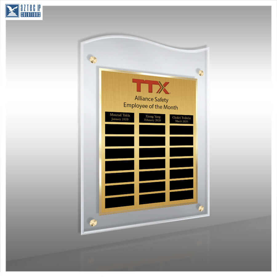 A vertical acrylic and metal employee of the month plaque on a gray gradient background. The plaque features a brushed gold center panel with red TTX branding, black nameplates, and a white arched border with gold corner accents.